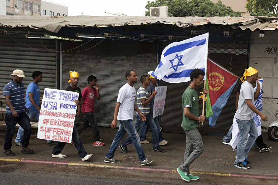 İsrail'de Eritre ve İsrail bayraklarıyla protesto yürüyüşü gerçekleştiren Eritreli mülteciler.
