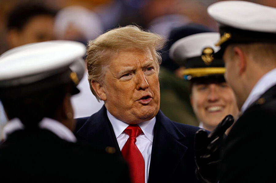 ABD Başkanı Donald Trump, katıldığı futbol maçında ABD'li askerlerle konuşuyor.