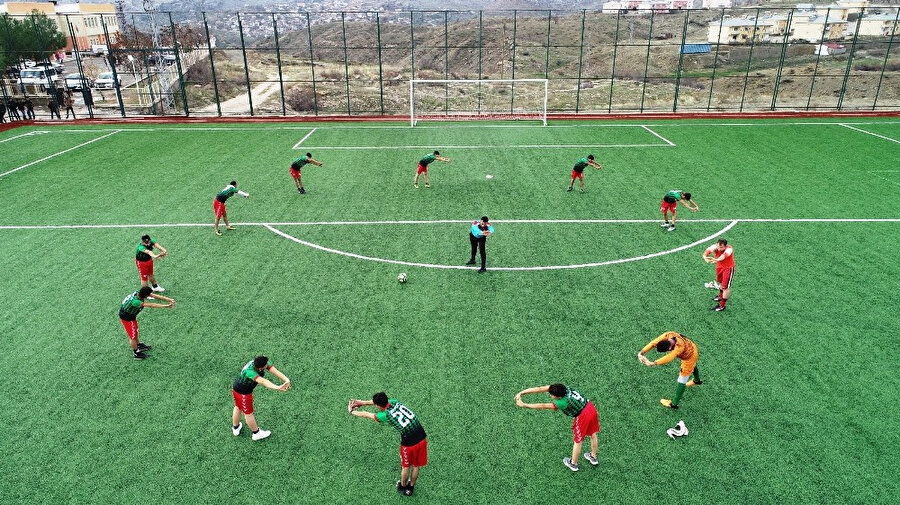 Çüngüş Gençliksporlu futbolcular ısınma hareketlerini yapıyor.