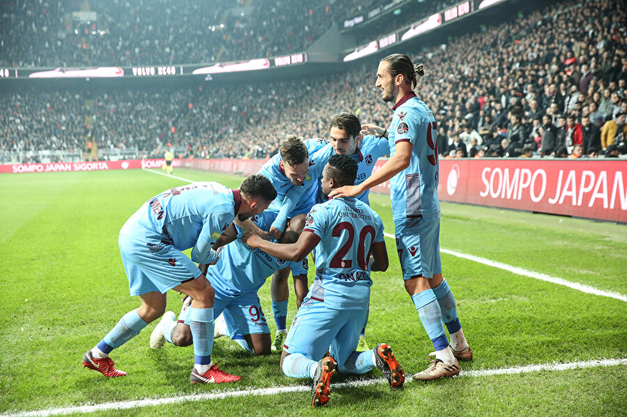 Trabzonspor forması giyen oyuncular köşe gönderinde golün sevincini paylaşıyor.