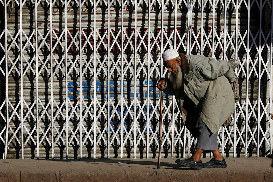 Pakistan'ın Karaçi şehrinde bastonundan destek alarak yürüyen yaşlı bir Pakistanlı.