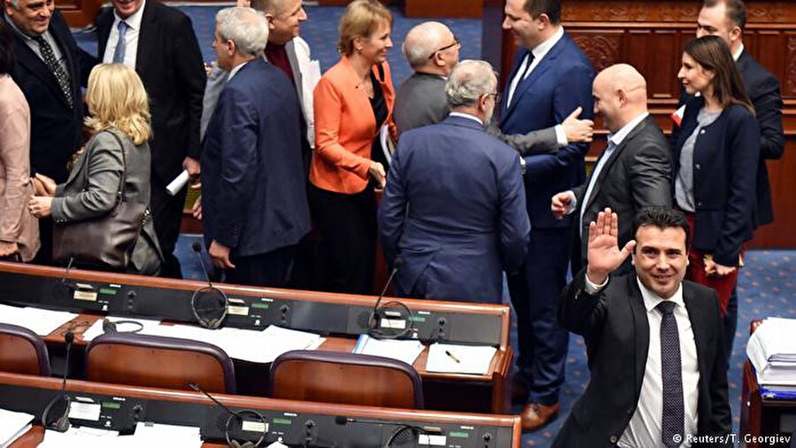 Makedonya Meclisi'nde isim değişikliği tasarısı kabul edildikten sonra milletvekilleri birbirlerini tebrik ederken, Makedonya Başbakanı Zoran Zaev (sağ) basın mensuplarına selam veriyor.