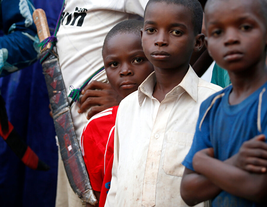 Orta Afrika Cumhuriyeti'nde 3 çocuk objektife bakıyor.