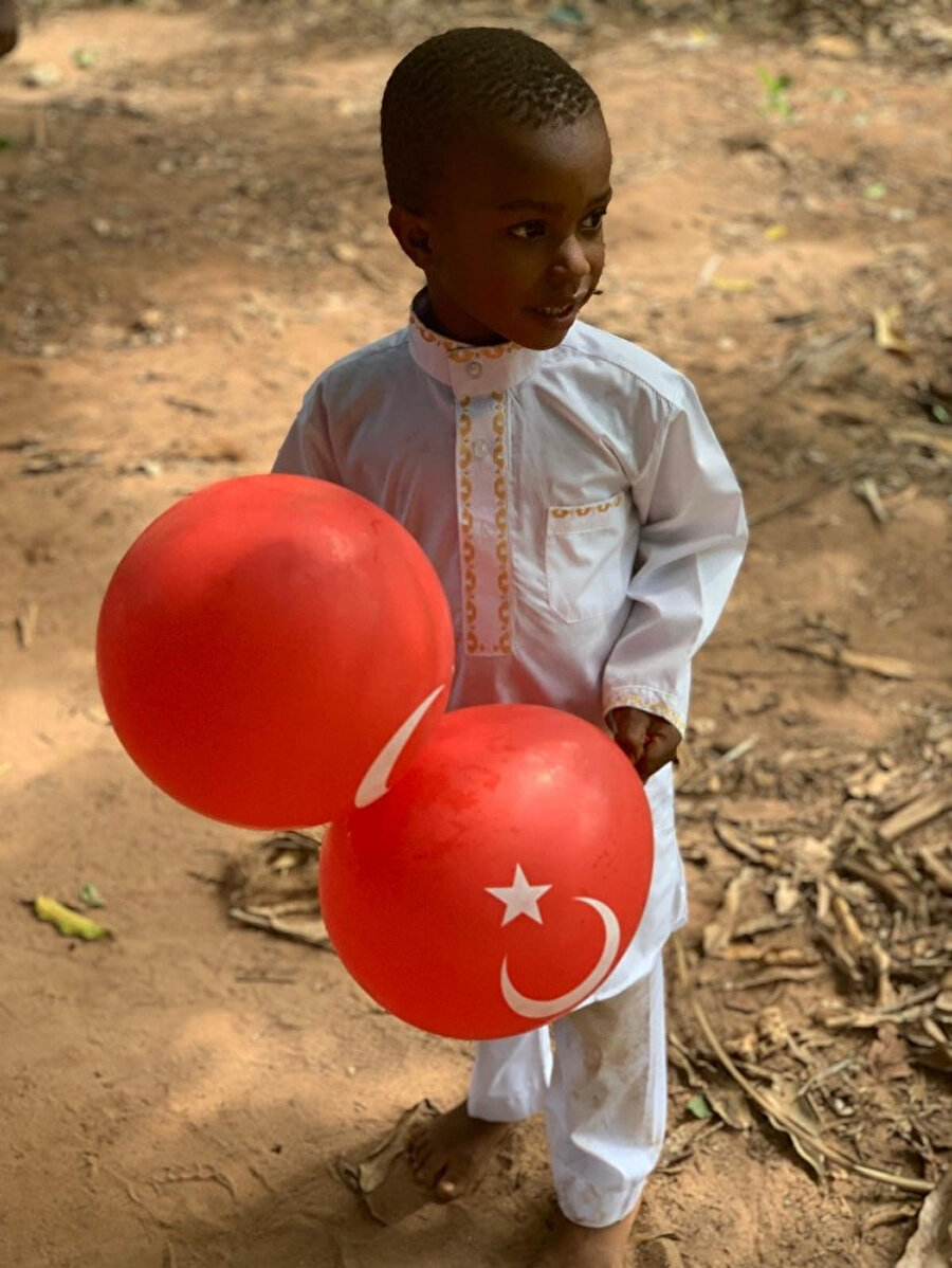 Afrikalı bir çocuk elinde Türk bayrağını temsil eden ay ve yıldız olan balonla görünüyor.