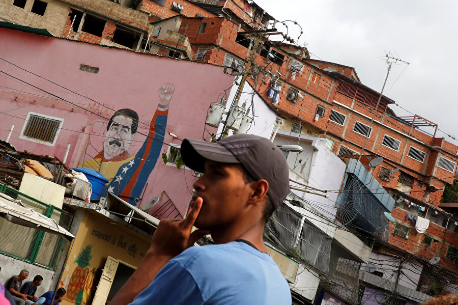 Duvardaki Maduro resminin önünde duran bir Venezuelalı.