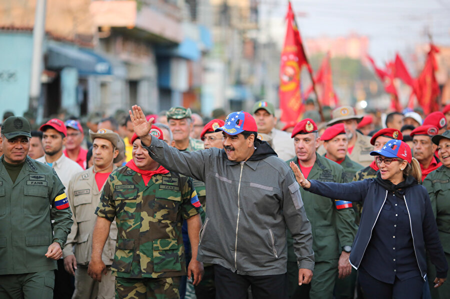 Maduro askerlerle birlikte yürüdüğü esnada kendisine sevgi gösterisinde bulunan Venezuela halkını selamladı.