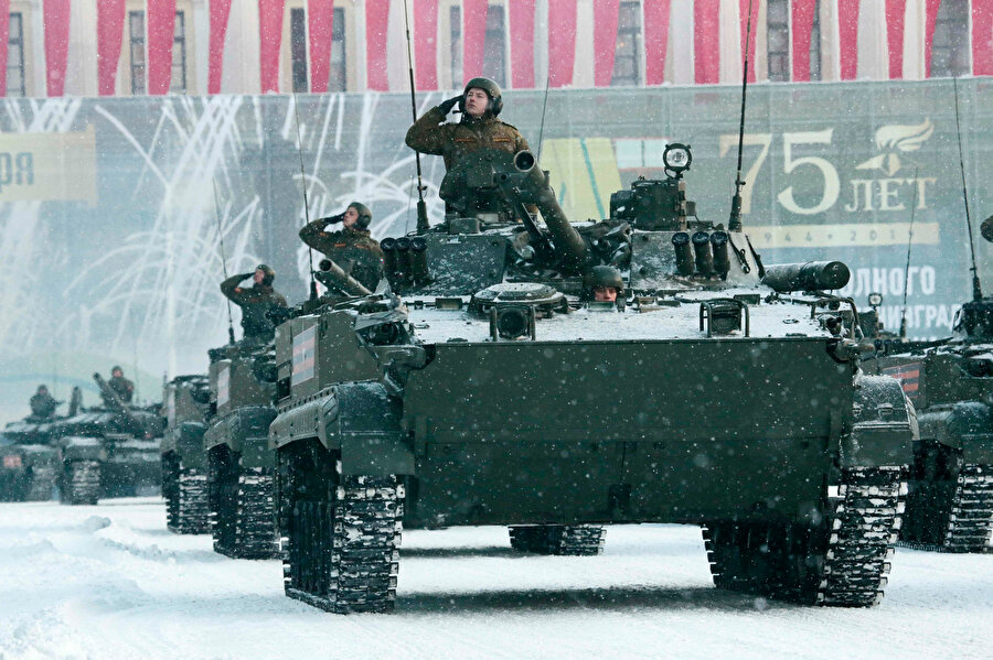 Askerler, Rusya savunmasına ait tanklardan selam veriyor.