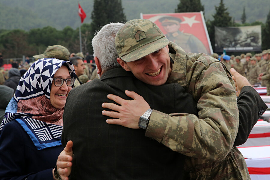 Yemin töreninden sonra ailesiyle kucaklaşan bir asker.