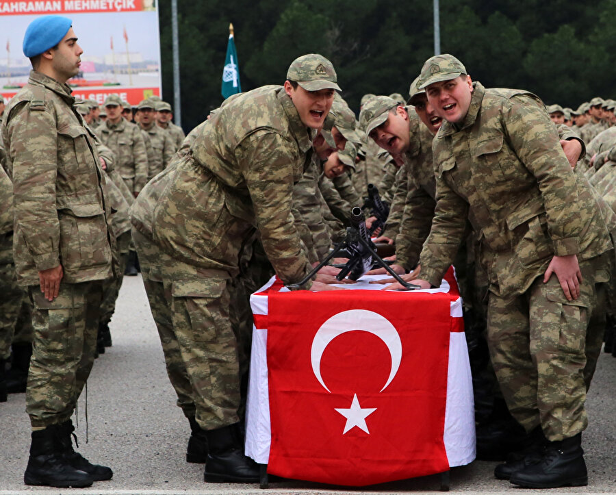 Yemin töreninde askerler Türk bayrağının üzerine ant içerken görünüyor.