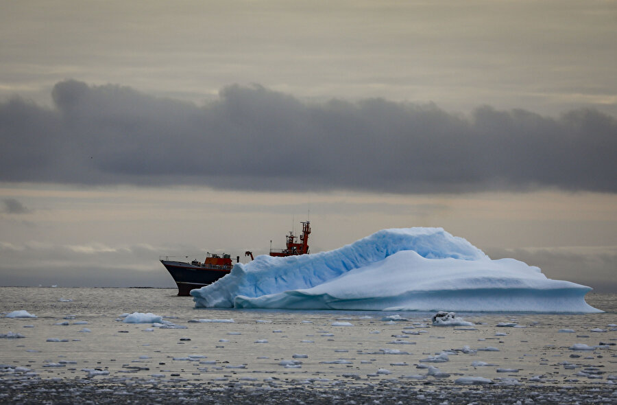 Buzulların arkasında görünen bir araştırma gemisi.