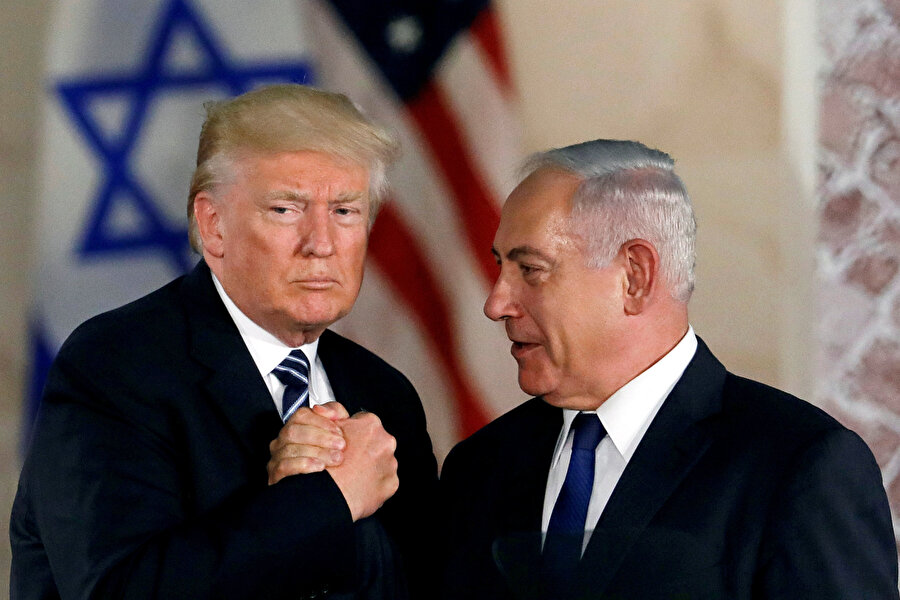 Trump ve İsrail Başbakanı Netanyahu el sıkışırken görünüyor.