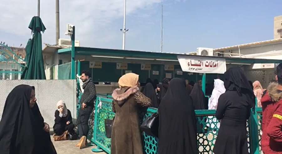 Bağdat’ın Kazımiye semtinde, İmam Musa Kazım türbesinin girişimde emanete telefon ve elektronik eşyalarını bırakmak için bekleyen kadınlar.