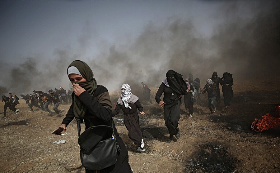 Atılan gaz bombalarından etkilenen direnişçi kadınlar.