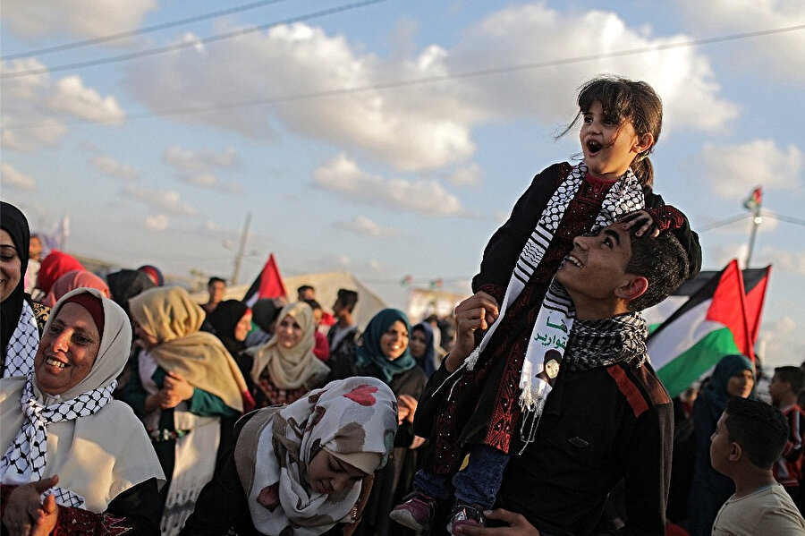 Filistinli göstericilerin barışçıl tutumlarını yüzlerinden okumak mümkün.