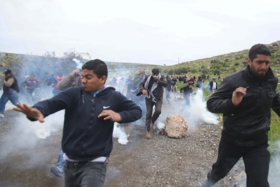 Atılan gaz bombalarından uzaklaşmaya çalışan Filistinliler.