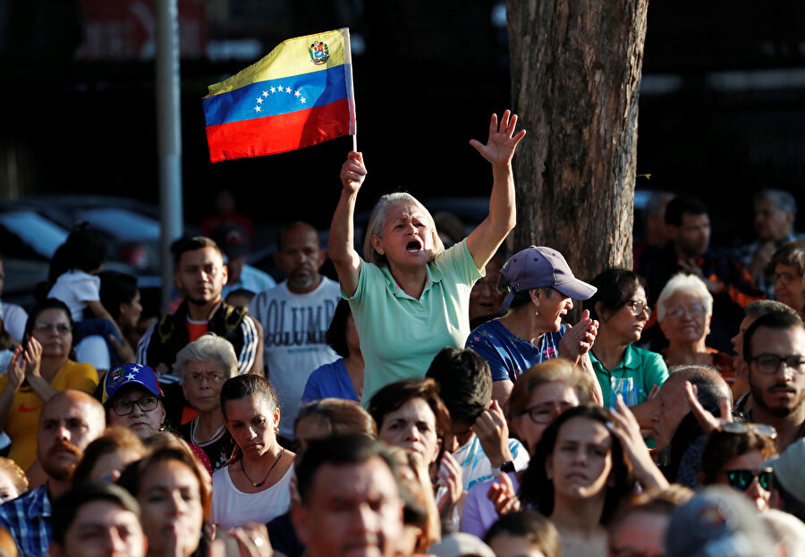 Venezuela'da düzenlenen gösteriler sırasın bir vatandaş bayrak sallıyor.