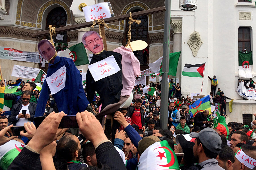Cezayirli işadamı Ali Haddad ve eski başbakan Ahmed Ouyahia'nın temsili olarak asıldığı gösteriler.