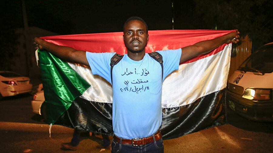 Sudan'da yeni Askeri Geçiş Konseyine karşı düzenlenen gösteriler esnasında ulusal bayrak ile gösteri yapan Sudanlı protestocu.