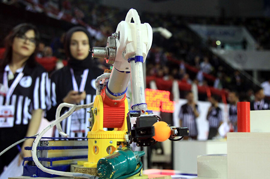 Yarışmaya katılan bir öğrenci ve robot kol.