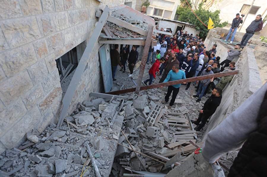Patlama sonrası evin etrafında enkaz kaldırmaya çalışan Filistinliler. 