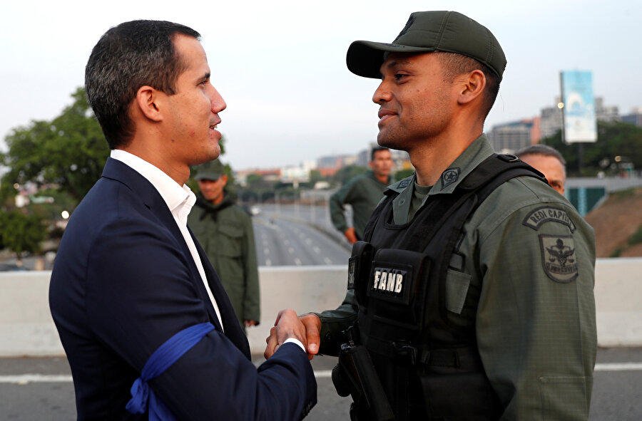 Guaido'nun da koluna mavi bant taktığı görülüyor.