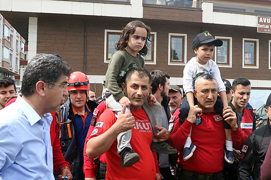 17 saat sonra bulunan iki çocuk, ekiplerin omuzlarında kaymakamlık binasına getirildi.