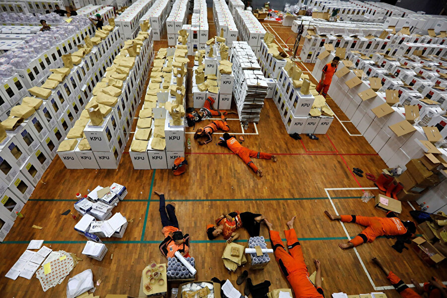 Başkent Jakarta'daki depoda seçim materyalleri hazırlayan işçilerin dinleme arası. 