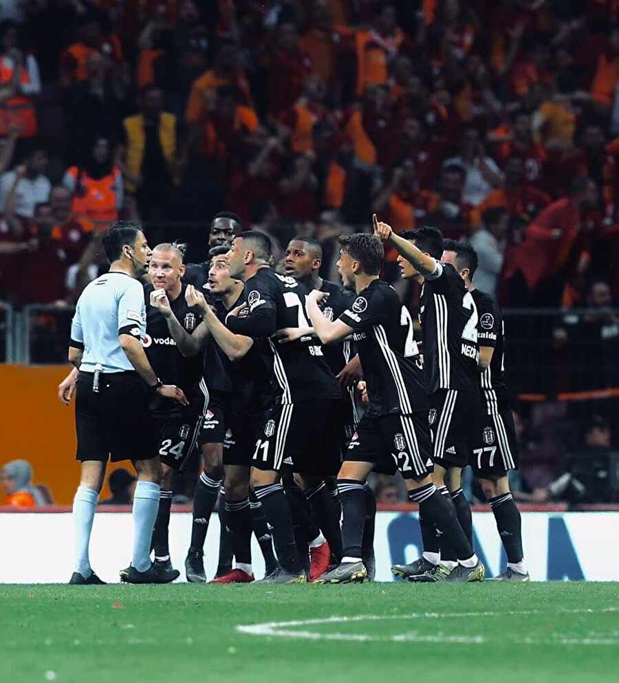 Beşiktaş forması giyen oyuncular, maçın tartışmalı hakemi Bülent Yıldırım'a itiraz ediyorlar.