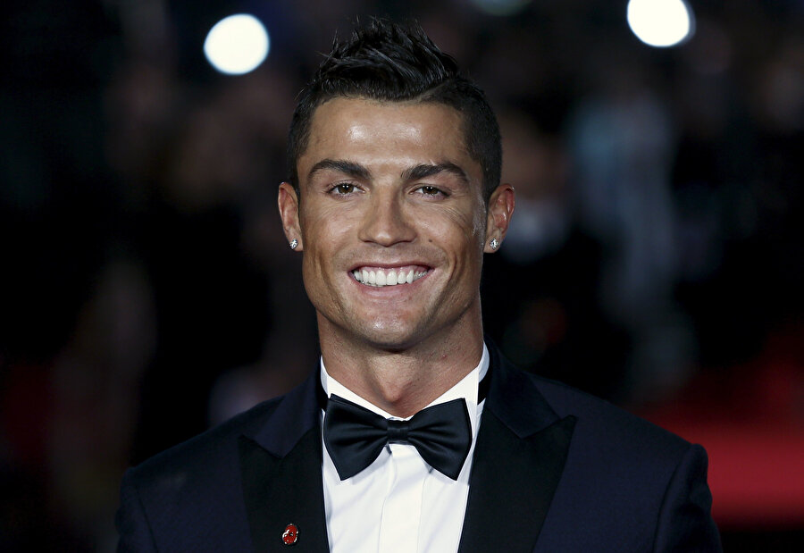 Cristiano Ronaldo ödül töreninde gazetecilere gülümsüyor.