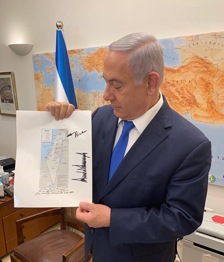 İsrail Başbakanı Netanyahu, ABD Başkanı Trump'ın damadı Jared Kushner’in kendisine verdiği, Golan Tepeleri’ni İsrail’in bir parçası olarak gösteren harita ile. Trump, tarafından Golan Tepelerinin kenarına "nice" (hoş/iyi/ güzel) notu düşülmüş. 