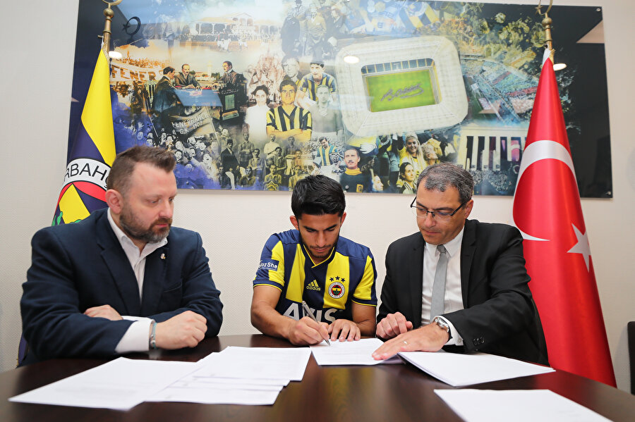 Genç futbolcu, kendisini Fenerbahçe'ye bağlayan mukaveleyi imzalıyor.