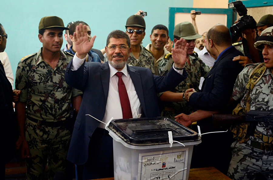 Mursi oy kullandığı sırada askerlerle birlikte görülüyor.