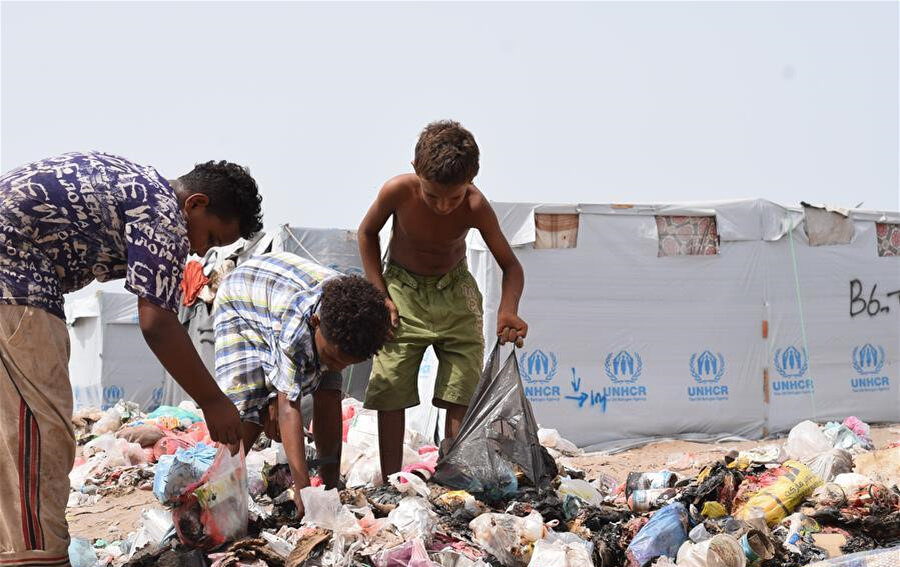 Aden'deki kamplarda yaşayan çocuklar, satıp paraya çevirmek için çöplerde dönüştürülebilir ürünler arıyor.