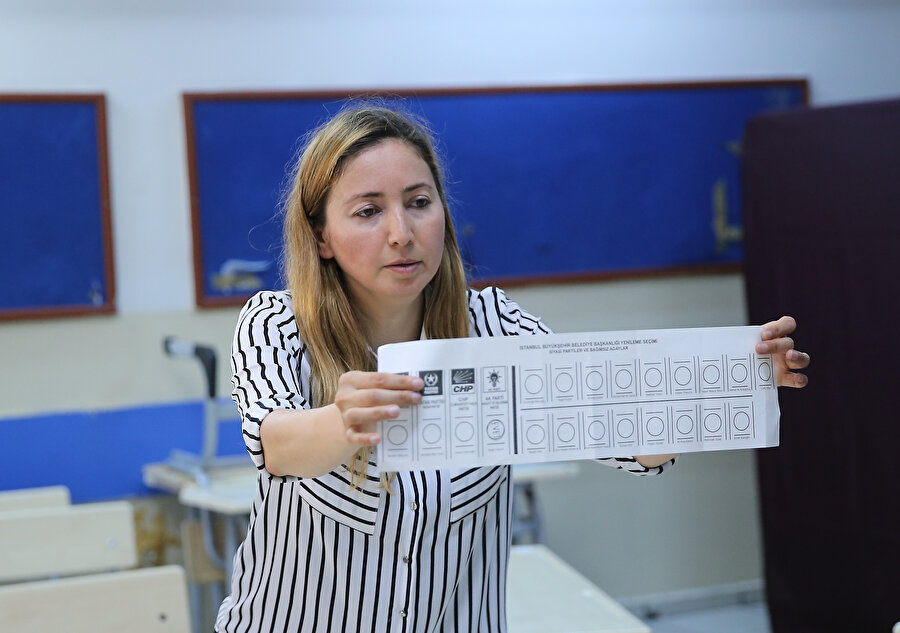 23 Haziran seçimlerinde oy pusulasını gösteren bir sandık görevlisi.