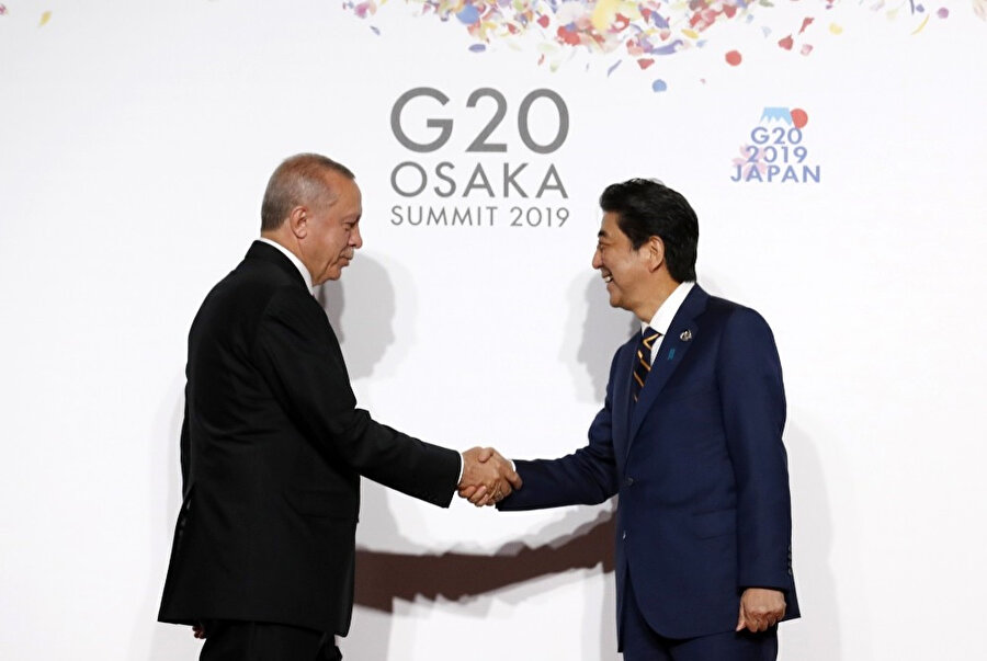 Japonya Başbakanı Şinzo Abe ve Cumhurbaşkanı Recep Tayyip Erdoğan selamlaşırken çekilen bir kare