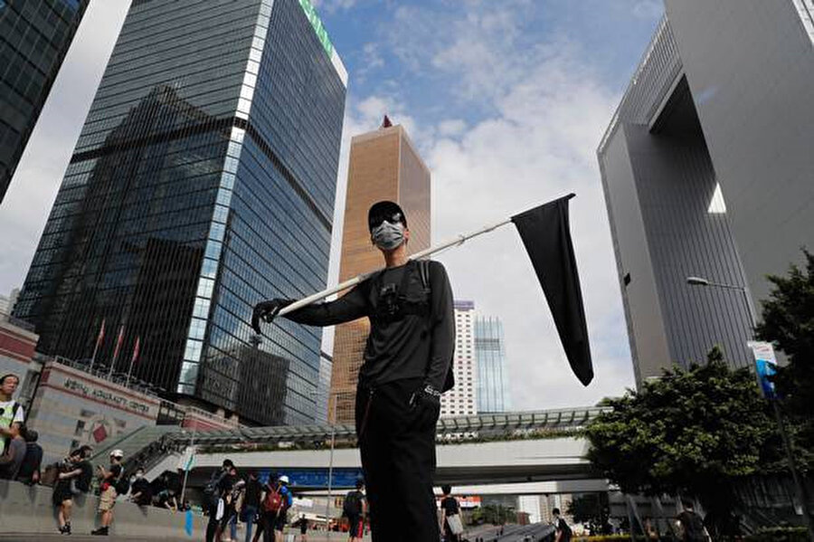 Bir protestocu Hong Kong için yasını sembolize etmek için siyah bir bayrak tutuyor 