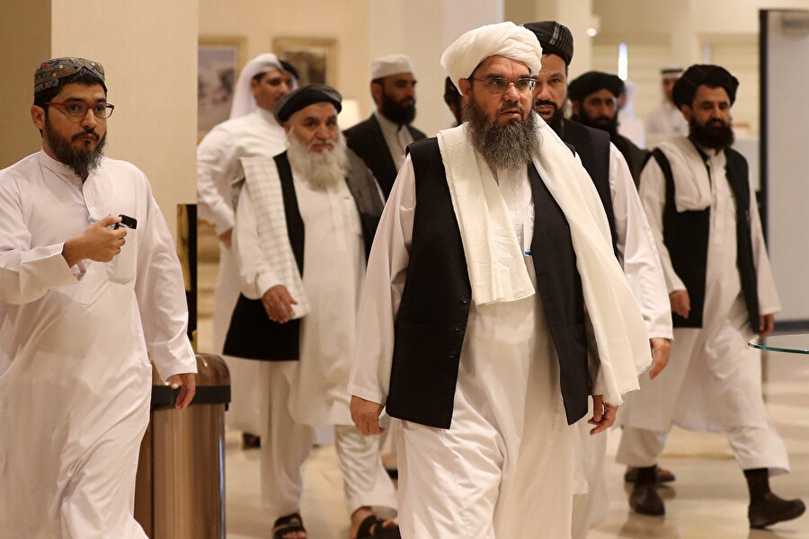 En önde ortada Taliba'nın eski Suudi Arabistan elçisi Şahabeddin Delavar, diğer Taliban mensuplarıyla birlikte konferansın gerçekleştirileceği alana gidiyor.