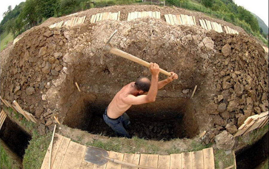 Bosnalı işçi, Potocari Mezarlığı'na defnedilecek Srebrenica kurbanları için açılacak 600 mezardan birini kazıyor. 08 Temmuz 2005.