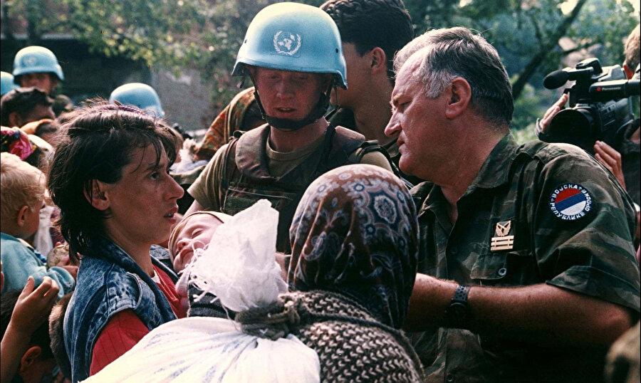 Ratko Mladic, BM Barış Gücü askerinin bakışları altında sürgüne gönderilecek kadın ve çocukları organize ediyor.
