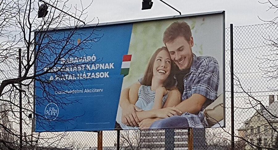  Orban'ın 'en az 4 çocuklu mutlu aile' kampanyası kapsamında Macaristan'da asılan posterler. Posterlerde 'Genç evli çiftler bebek beklerken devlet desteği alacak' yazıyor. 