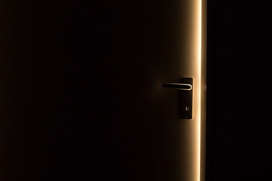 Kapıdan sızan ışığa bakıp yasanın içerde bir yerde mukim ya da müheyya olduğunu zannetmektedir.