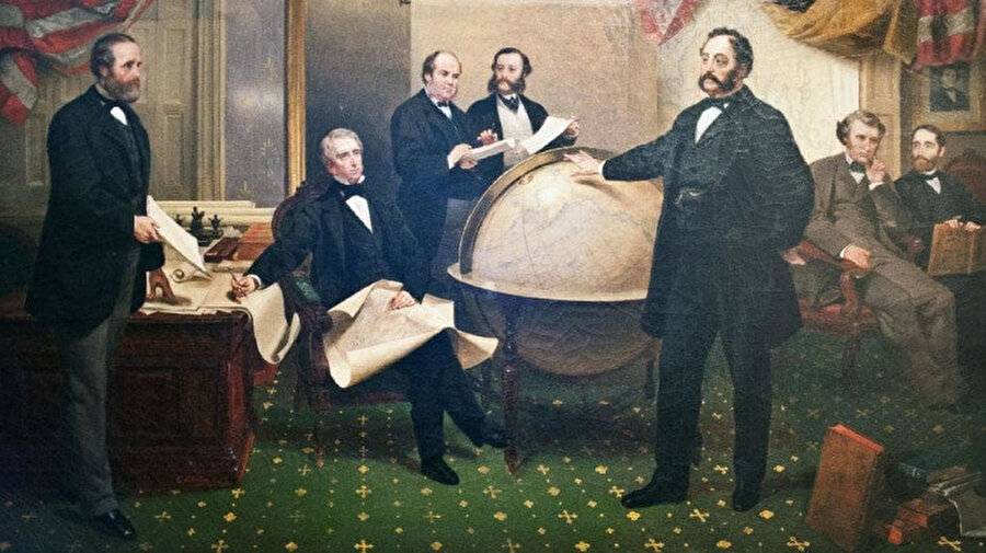 ABD Dışişleri Bakanı William Seward (oturmuş) Rusya'nın ABD Büyükelçisi Baron Edouard de Stoeckl (sağda duruyor) ile 1867'de Washington DC'de Alaska Satın Alma Anlaşması imzaladı.