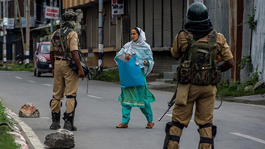 Kısıtlamaların tam ortasındaki Keşmir'de hastaneye gitmekte olan bir kadını durduran Keşmir polisi.