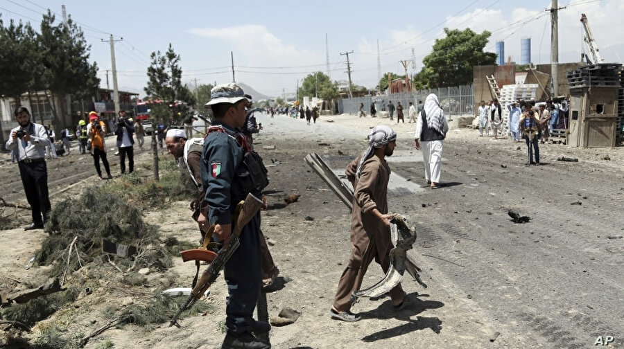 İntihar saldırısını gerçekleştiren araçtan kalanları toplayan bir Afgan, Mayıs 2019.
