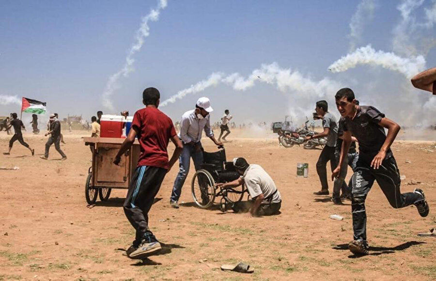 Gazze şeridindeki protestolar sırasında İsrail güçleri tarafından Filistinli göstericilere göz yaşartıcı gaz fırlatılıyor.
