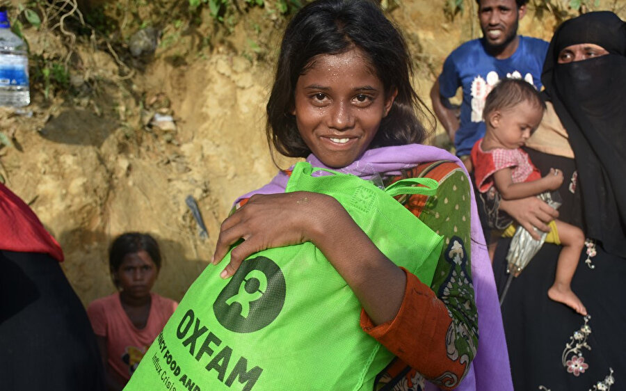 13.500 kişinin yardım beklediği Bangledeş'teki mülteci kampında yardım almayı başaran Arakanlı kızın mutluluğu yüzünden okunuyor.