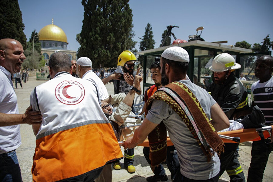 İsrail polisinin müdahalesi sonucu yaralanan Filistinli'yi ambulansa taşıyan sağlık görevlileri, Haziran 2019.