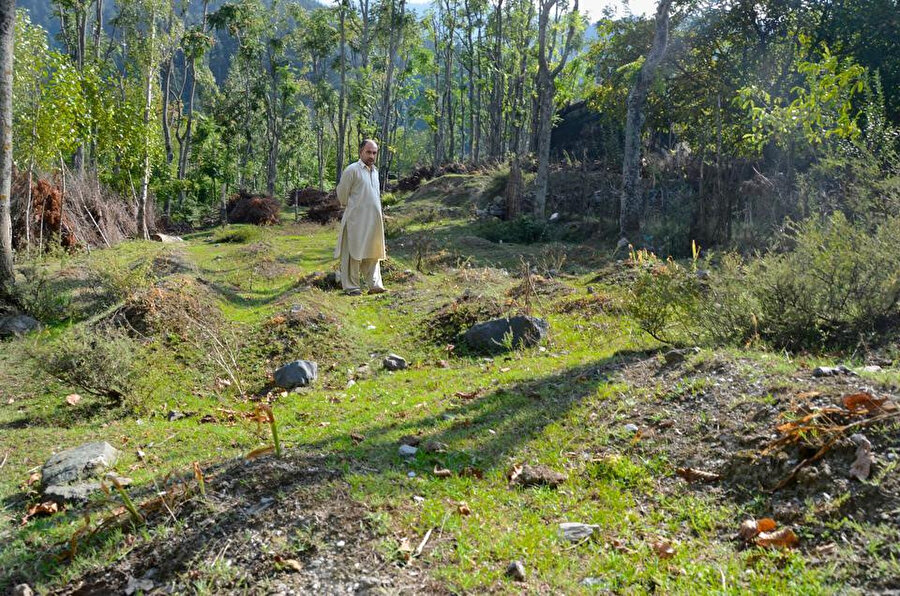 Keşmir'deki Baramulla bölgesinde bir köyde ortaya çıkarılan toplu mezarın bekçiliğini yapan bir Keşmirli.