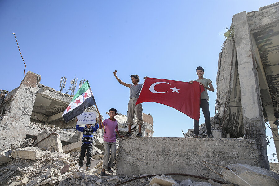 Fırat Kalkanı Harekatı ile temizlenen bölgede elinde Türkiye ve Suriye bayrakları olan çocuklar böyle görüntülenmişti.