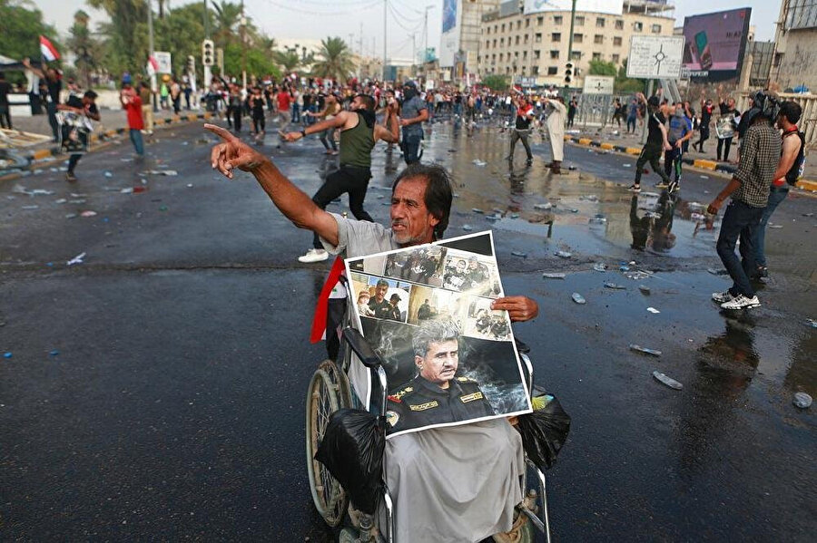 Irak'ta 1 Ekim'de başlayan protestolar sırasında görevinden azledilen General Saadi'nin posterini taşıyan bir gösterici.